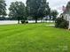 Lush green backyard with mature trees and waterfront access at 4574 Ivy Run Ln, Denver, NC 28037
