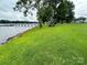 Expansive backyard with lush green grass leading to a serene waterfront at 4574 Ivy Run Ln, Denver, NC 28037