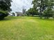 Large, green backyard with mature trees and a charming house in the background at 4574 Ivy Run Ln, Denver, NC 28037