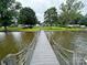 Wooden dock extends into a calm lake surrounded by lush green landscape and homes at 4574 Ivy Run Ln, Denver, NC 28037