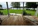 Covered porch with wooden decking overlooks a lush green lawn and waterfront at 4574 Ivy Run Ln, Denver, NC 28037