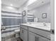 Bright bathroom features a double sink vanity, framed mirror, and stylish striped shower curtain at 515 Benford Ln, Stanley, NC 28164