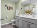 Stylish bathroom featuring double vanity with gray cabinets, large mirror, and tile floors at 515 Benford Ln, Stanley, NC 28164