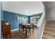 Cozy dining room with dark teal walls, a wooden table, and natural light from the window, ideal for gatherings at 515 Benford Ln, Stanley, NC 28164