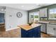 Bright kitchen featuring a blue island with wood countertop, stainless steel appliances, and sliding glass doors to the backyard at 515 Benford Ln, Stanley, NC 28164