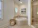 Elegant bathroom showcasing a soaking tub with tiled surround and a glass-enclosed shower for spa-like comfort at 525 Queens Rd, Charlotte, NC 28207