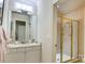Bathroom featuring a well-lit vanity and a glass-doored shower for a clean and functional space at 525 Queens Rd, Charlotte, NC 28207