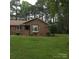 Charming brick home featuring a well-manicured lawn, mature trees, and inviting curb appeal at 600 Colby Cir, Salisbury, NC 28147