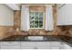 Bright kitchen area with a large window offering serene outdoor views and granite countertops at 6101 Heath Ridge Ct, Charlotte, NC 28210