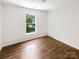 Bedroom featuring hardwood floors and a large window at 6413 Fillian Ln, Charlotte, NC 28269