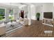 Bright, staged living room with hardwood floors, decorative fireplace, and inviting furniture at 6413 Fillian Ln, Charlotte, NC 28269