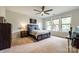 Bright bedroom with large windows, neutral carpet, ceiling fan, and wooden furniture at 7026 Wyngate Pl, Lancaster, SC 29720