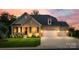 Charming brick home featuring a well-manicured lawn, inviting front porch, and a spacious three-car garage at 7026 Wyngate Pl, Lancaster, SC 29720