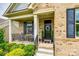 Inviting front porch with rocking chairs, manicured landscaping, and a welcoming front door with wreath at 7026 Wyngate Pl, Lancaster, SC 29720