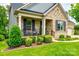 Inviting front porch with rocking chairs, lush landscaping, and charming brick facade at 7026 Wyngate Pl, Lancaster, SC 29720