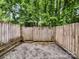 Backyard view featuring a wood fence, gravel, and mature trees at 7609 Holly Grove Ct, Charlotte, NC 28227