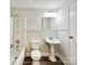 Clean bathroom with white fixtures, wainscoting, and wood-look flooring at 7609 Holly Grove Ct, Charlotte, NC 28227