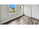 Bright bedroom featuring laminate flooring, two windows, and a double-door closet at 7609 Holly Grove Ct, Charlotte, NC 28227