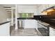 Well-equipped kitchen featuring stainless steel appliances, granite counters, and sleek white cabinetry at 7609 Holly Grove Ct, Charlotte, NC 28227