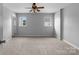 A spacious bedroom featuring neutral carpeting and two bright, sunlit windows at 7943 Mariners Pointe Cir, Denver, NC 28037