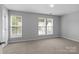 The large bedroom boasts natural light from multiple windows and soft, neutral carpeting at 7943 Mariners Pointe Cir, Denver, NC 28037