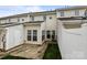 Exterior view of the back of a light colored townhouse, with a small patio and green grass at 7943 Mariners Pointe Cir, Denver, NC 28037