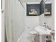 Traditional bathroom with black and white tile, pedestal sink and shelves with decorations at 829 Sedgefield Rd, Charlotte, NC 28209