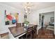 Inviting dining room with hardwood floors, a modern chandelier, and an adjacent living room at 829 Sedgefield Rd, Charlotte, NC 28209