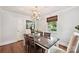 Cozy dining room with hardwood floors, modern lighting, and a view of the living area at 829 Sedgefield Rd, Charlotte, NC 28209