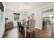Bright dining room features hardwood floors, stylish light fixture, and adjacent kitchen access at 829 Sedgefield Rd, Charlotte, NC 28209