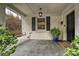 Cozy front porch with brick siding, hanging light fixture, and a welcoming porch swing at 829 Sedgefield Rd, Charlotte, NC 28209