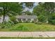 Well-maintained home featuring a lush lawn, decorative shrubbery, and classic black shutters at 829 Sedgefield Rd, Charlotte, NC 28209