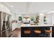 Bright kitchen with white cabinets, an island with seating, stainless steel appliances, and hardwood floors at 829 Sedgefield Rd, Charlotte, NC 28209