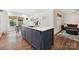Kitchen island with sink, seating, and view to dining and living space with hardwood floors at 829 Sedgefield Rd, Charlotte, NC 28209