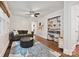 Living room boasts hardwood floors, built-in shelving, neutral paint, and an ottoman at 829 Sedgefield Rd, Charlotte, NC 28209