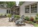 Charming backyard patio with outdoor seating, lush greenery, and a view of the screened porch at 829 Sedgefield Rd, Charlotte, NC 28209