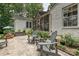 Charming backyard patio with outdoor seating, lush greenery, and a view of the screened porch at 829 Sedgefield Rd, Charlotte, NC 28209