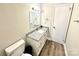 Neat bathroom featuring a granite countertop vanity, a toilet, and modern light fixtures at 901 Echo Glen Rd, Charlotte, NC 28213