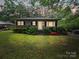 Charming single-story home at dusk, framed by mature trees providing ample shade and curb appeal at 1004 E 8Th Ave, Gastonia, NC 28054