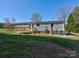 Home with a large deck and a spacious lawn overlooking mature trees and the exterior features of the home at 1038 Gold Mine Dr, Catawba, NC 28609