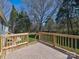 A fenced backyard featuring a lush lawn, mature trees, and a wooden deck with handrails for added safety at 1038 Gold Mine Dr, Catawba, NC 28609