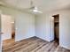 Open bedroom featuring wood-look floors, ceiling fan, an open closet, and neutral paint throughout the home at 1038 Gold Mine Dr, Catawba, NC 28609