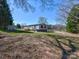 Exterior view of a single-story home with light gray siding, a wooden deck, and spacious lawn at 1038 Gold Mine Dr, Catawba, NC 28609