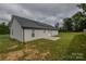 Backyard with lush green grass and the home's exterior, featuring solar panels on the roof at 108 Devynne Ct, Salisbury, NC 28146