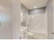 Well-lit bathroom with tub, white cabinets, gray walls, and a decorative white medicine cabinet at 108 Devynne Ct, Salisbury, NC 28146