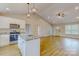 Open kitchen with granite countertops and white island flowing into spacious living space with wood floors at 108 Devynne Ct, Salisbury, NC 28146