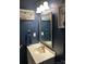 A well-lit bathroom with a white sink and vanity, decorative mirror and wall art at 114 Wayne Ave, Kannapolis, NC 28081