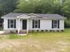 Charming single-story home with gray siding, black shutters, and a welcoming front porch at 12 Watts St, York, SC 29745