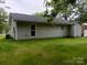 Exterior view featuring neutral siding, well-maintained lawn, and view of the home's back and roof at 12 Watts St, York, SC 29745