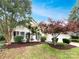 Well-maintained front yard with mature trees, shrubs, and a charming facade at 12307 Poplar Forest Dr, Charlotte, NC 28278